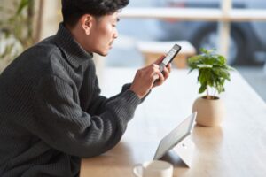 Customer securely using multi-factor authentication on a mobile phone and a tablet while working remote from a café.
