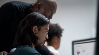 Three security experts looking at a computer.
