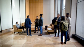 Developers on-the-go, meeting up in the lobby. Male and female developers collaborating outside the office.