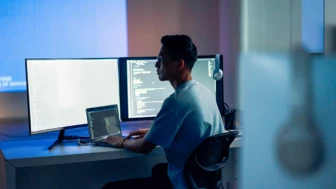 Computer developer working at night in office.