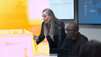 A woman pointing at a computer screen.